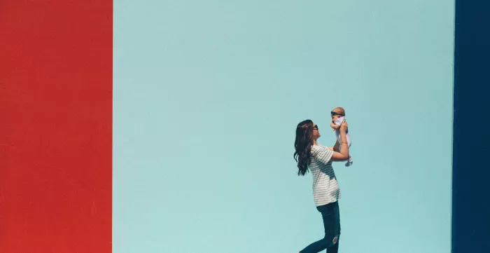 A woman holding up a baby