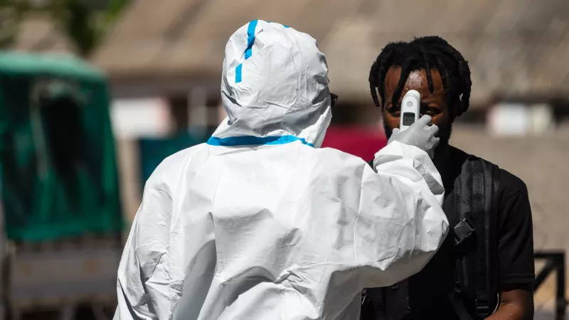 A man gets his temperature checked at the entrance gate of Mpilo Hospital.