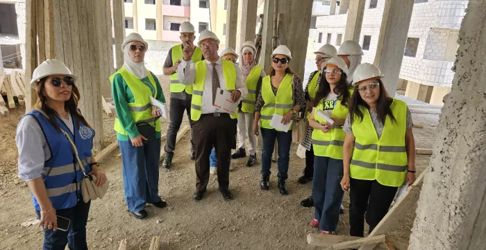 a group of men an women in a field visit to a construction site